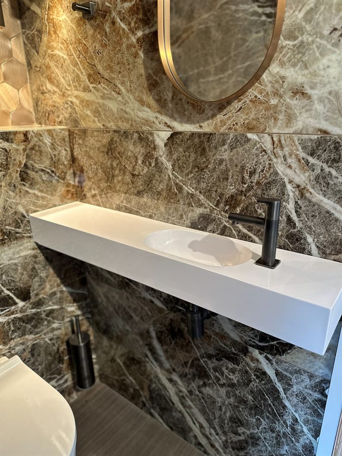 Gastentoilet met marmerdessin en wandwastafel
